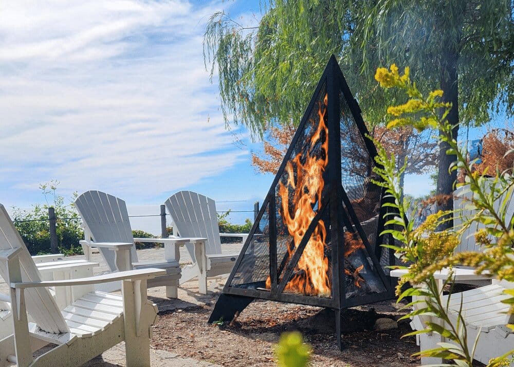 Octagonal Cottager fire pit glowing in an outdoor seating area.